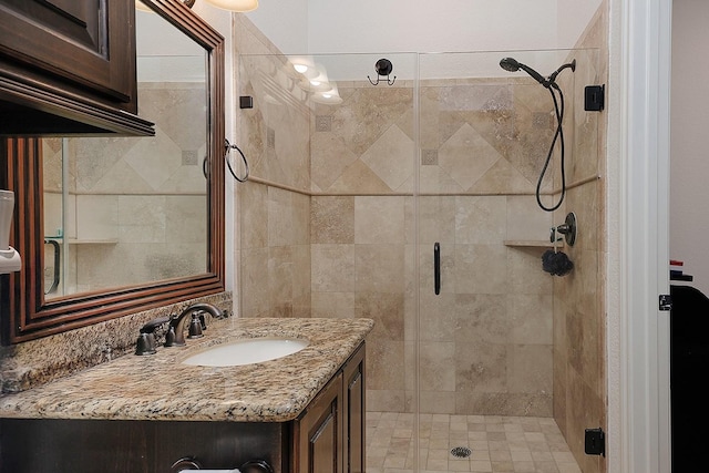 bathroom with a shower with door and vanity