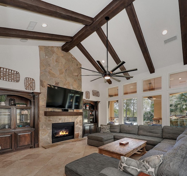 living room featuring ceiling fan, a stone fireplace, high vaulted ceiling, and beamed ceiling