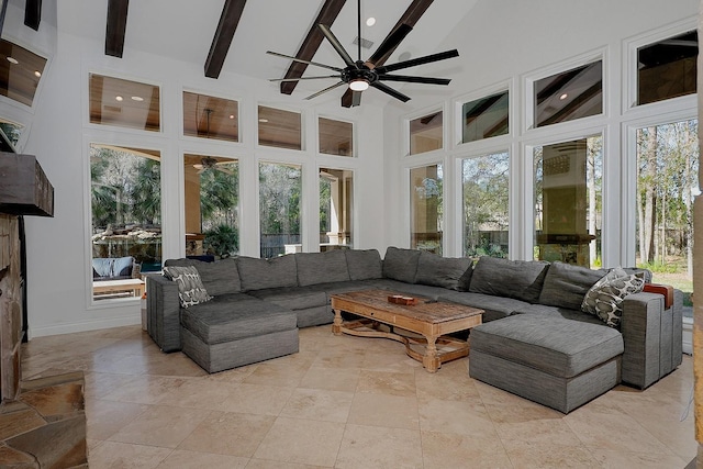 sunroom / solarium featuring ceiling fan and beamed ceiling