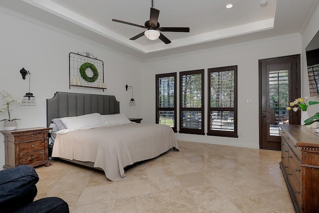 bedroom featuring a tray ceiling, ornamental molding, and ceiling fan