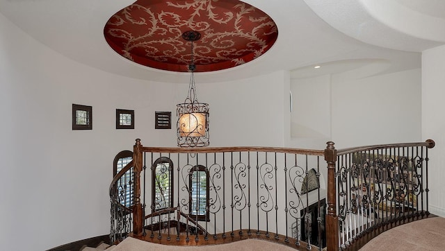 stairway featuring a raised ceiling