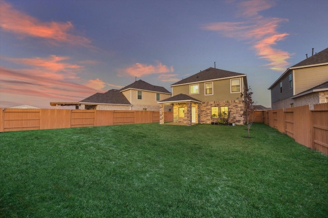 back house at dusk with a yard