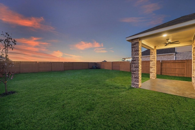 yard at dusk with a patio area and ceiling fan