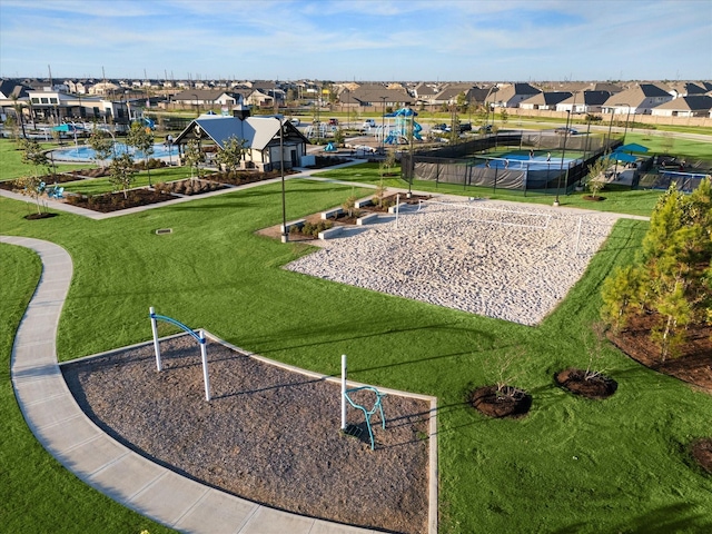 view of community with volleyball court and a lawn