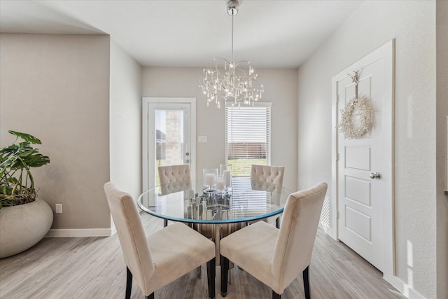 dining space with a chandelier and light hardwood / wood-style floors