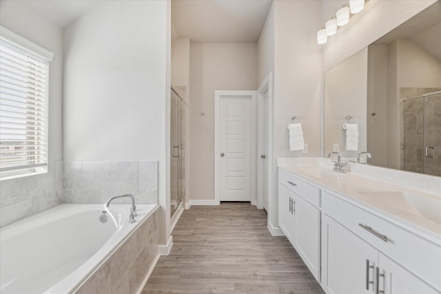 bathroom with vanity, hardwood / wood-style flooring, and shower with separate bathtub