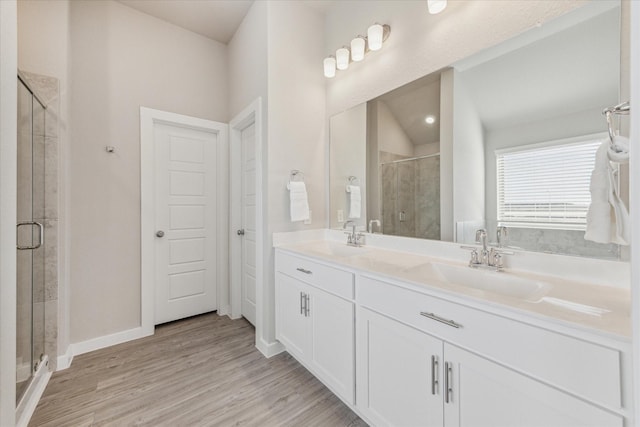 bathroom with vanity, a shower with shower door, and hardwood / wood-style floors