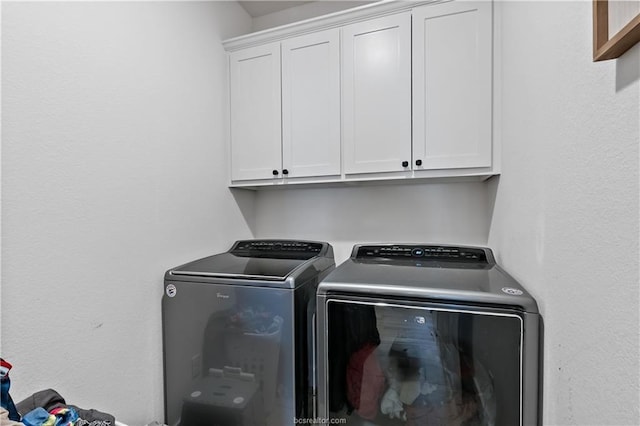 laundry area featuring cabinets and washer and clothes dryer