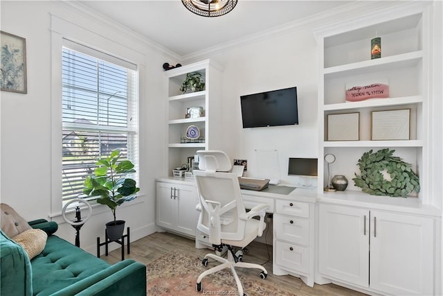 office area with crown molding, light hardwood / wood-style floors, and built in shelves