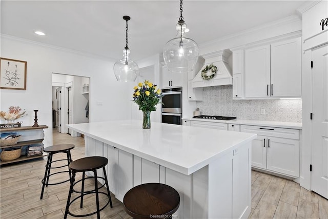 kitchen with double oven, a center island, and white cabinets