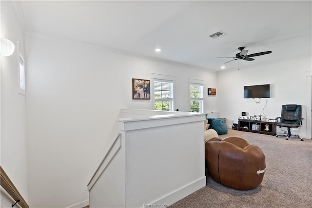 carpeted living room featuring crown molding and ceiling fan