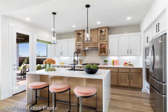 kitchen featuring white cabinetry, appliances with stainless steel finishes, sink, and a kitchen island with sink