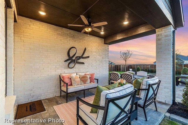 patio terrace at dusk with outdoor lounge area and ceiling fan