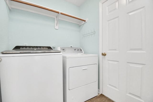 washroom with wood-type flooring and washer and dryer