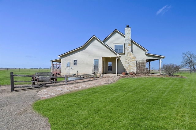 back of property with a lawn and a rural view