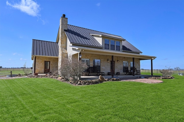 back of house with a patio area, a lawn, and solar panels