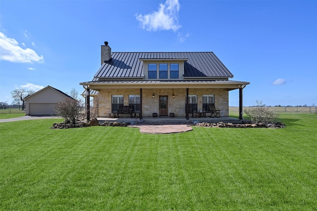 back of house featuring a garage, a lawn, solar panels, and covered porch