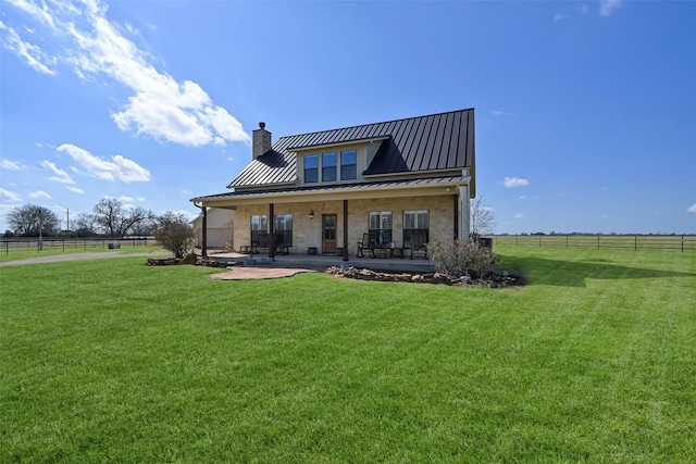 back of property featuring a porch, a yard, and a rural view