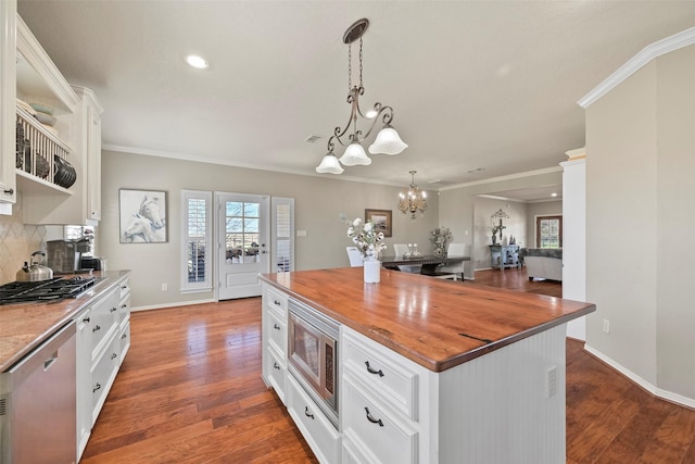 kitchen featuring white cabinetry, a center island, wooden counters, and appliances with stainless steel finishes