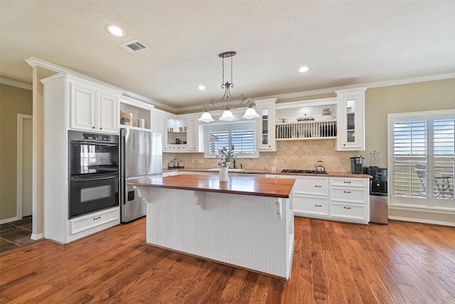 kitchen featuring white cabinetry, wooden counters, decorative light fixtures, a kitchen island, and black appliances