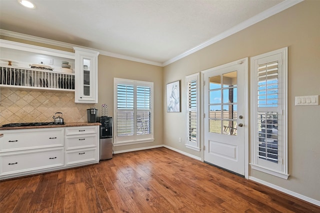 kitchen with crown molding, white cabinets, dark hardwood / wood-style flooring, and decorative backsplash