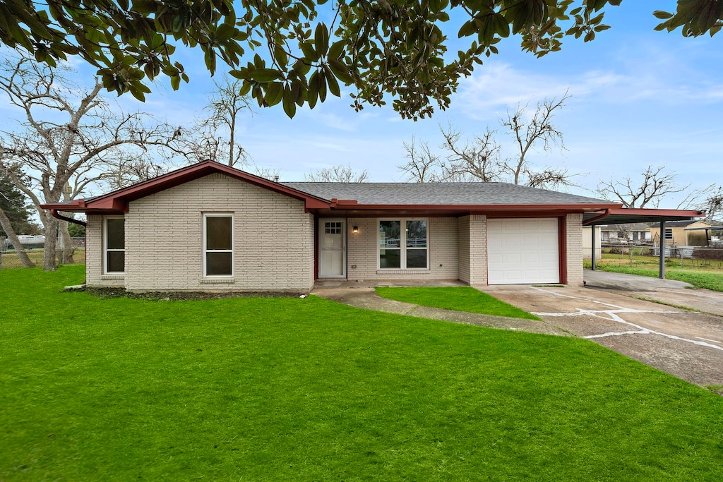 view of front facade with a carport, a garage, and a front lawn