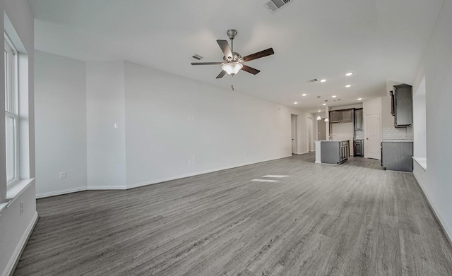 unfurnished living room featuring ceiling fan and dark hardwood / wood-style floors