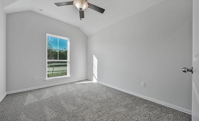 empty room with lofted ceiling, ceiling fan, and carpet flooring