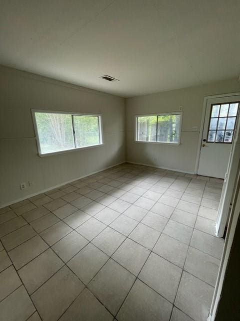 tiled spare room featuring plenty of natural light