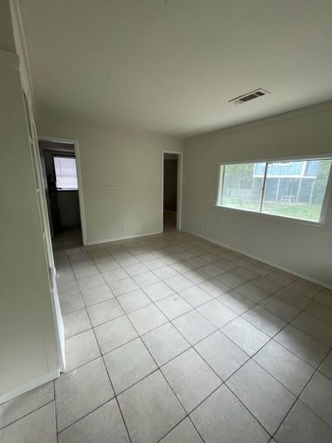 spare room with light tile patterned floors and plenty of natural light