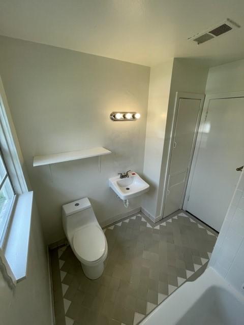 bathroom with toilet, tile patterned flooring, and sink