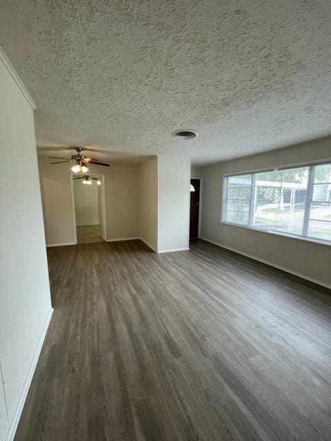 unfurnished living room featuring ceiling fan, dark hardwood / wood-style floors, and a textured ceiling