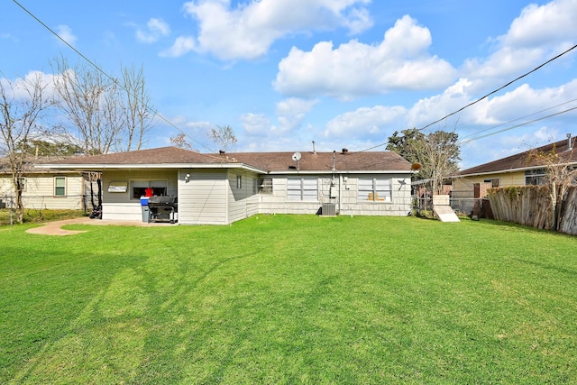 back of property featuring central AC and a lawn