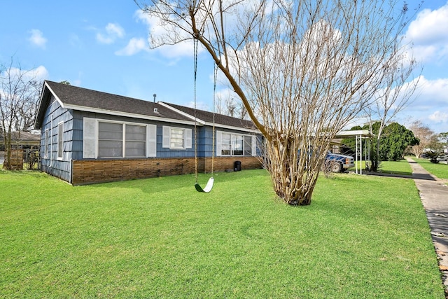 ranch-style house featuring a front yard and a carport