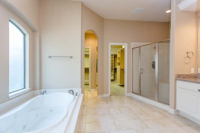 bathroom featuring tile patterned flooring, plus walk in shower, and vanity