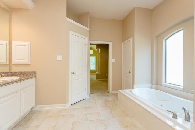 bathroom with tile patterned floors, tiled bath, and vanity