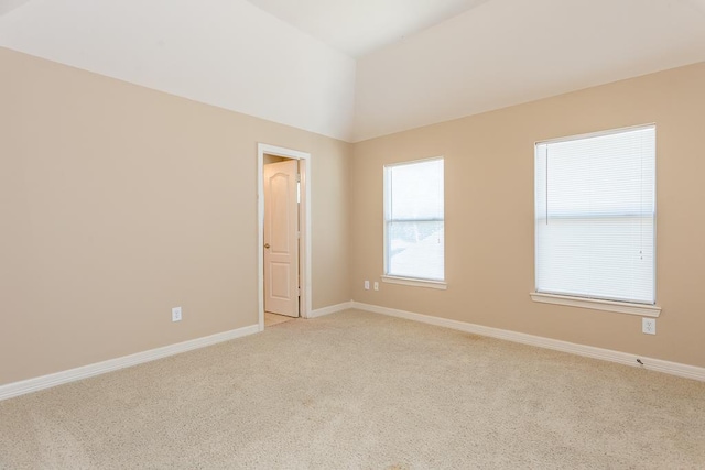 empty room featuring lofted ceiling and light colored carpet