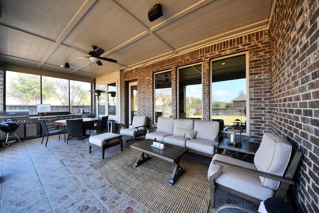 view of patio / terrace featuring ceiling fan, an outdoor living space, grilling area, and exterior kitchen