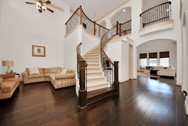 living room with ceiling fan and dark hardwood / wood-style flooring