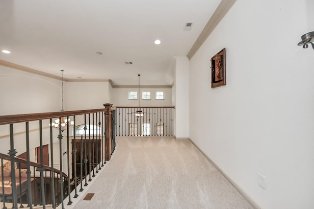 hall with crown molding, carpet floors, and a notable chandelier