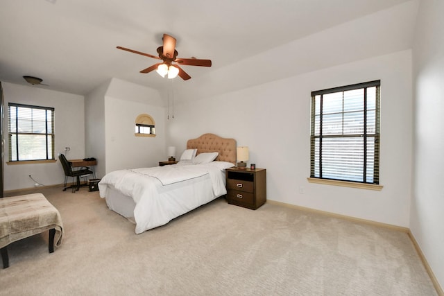 bedroom featuring ceiling fan, multiple windows, and light carpet