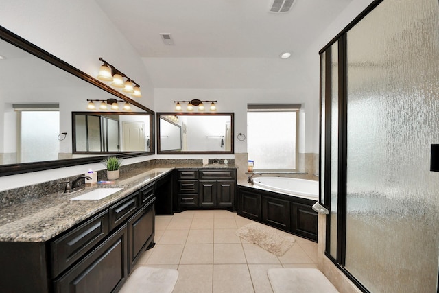 bathroom with tile patterned floors, shower with separate bathtub, vaulted ceiling, and vanity