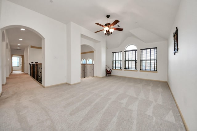 spare room featuring light colored carpet and lofted ceiling