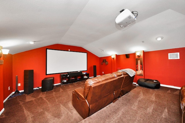 carpeted cinema room with vaulted ceiling