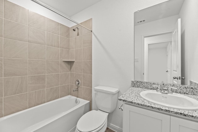 full bathroom featuring tiled shower / bath, vanity, and toilet