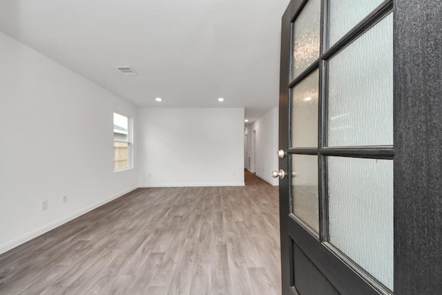 spare room with light wood-style floors, visible vents, baseboards, and recessed lighting