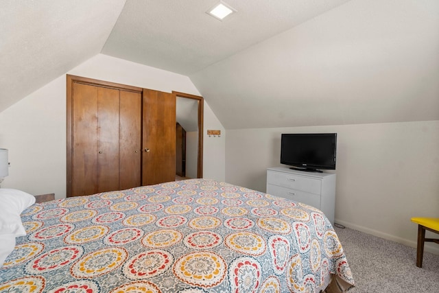 carpeted bedroom featuring a closet, lofted ceiling, and a textured ceiling