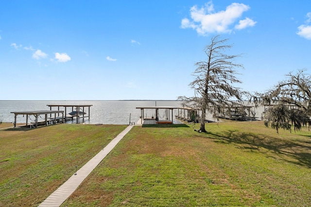 view of dock with a water view and a lawn