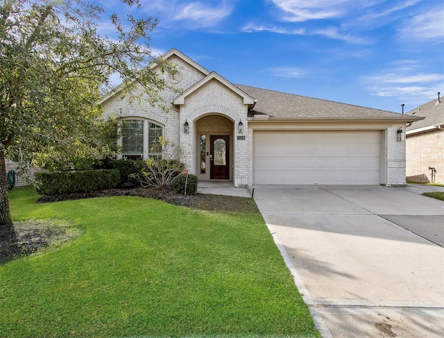 view of front facade with driveway, brick siding, an attached garage, and a front yard