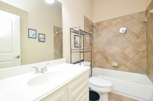 full bathroom featuring tile patterned flooring, tiled shower / bath, vanity, and toilet